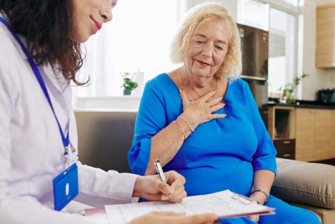 A care assessor talking with an older lady at home